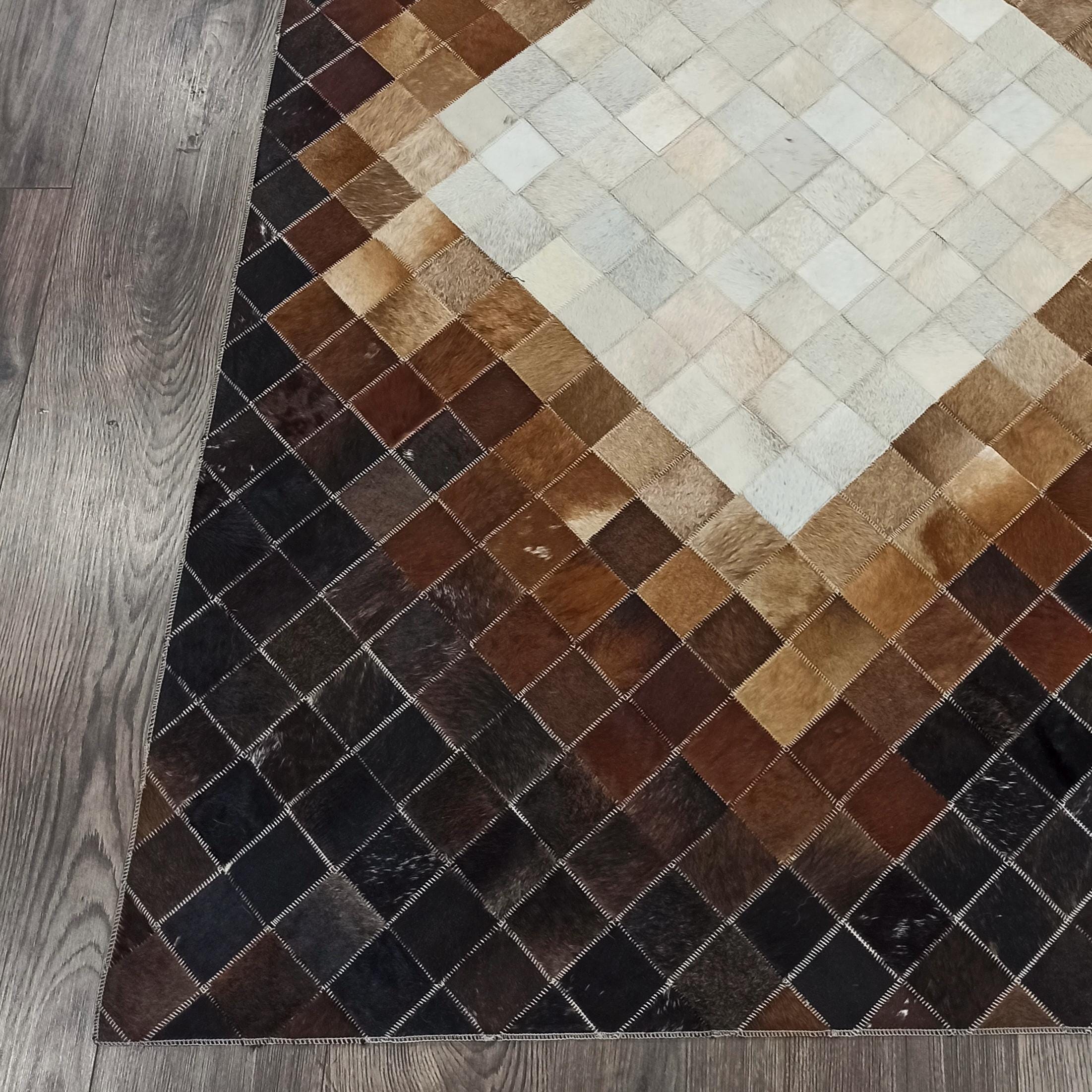 El Yapımı Koyu Kahve Patchwork Halı – Beyaz Kare Desenli Dana Derisi Şık Ortam Halısı