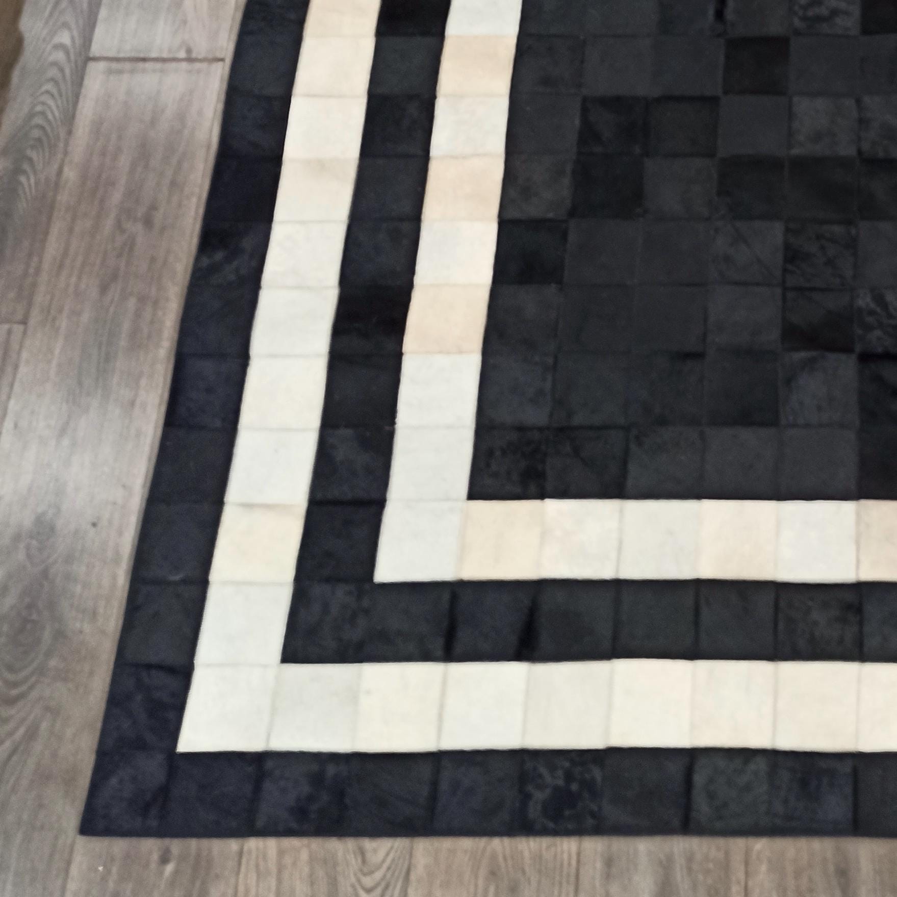Beyaz Çerçeveli Siyah Dana Derisi Halı – El Yapımı Şık Patchwork Salon Halısı